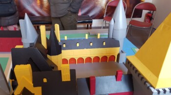 Rumena trikotna streha na kvadratnem stolpu in arkadni hodnik na notranjem dvorišču.