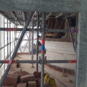 S šablono so obnovili obrabljen kamnik obok na stolpu.