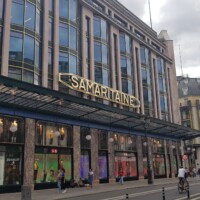 Pogled z rue Rivoli. Samaritaine 3 v art deco stilu, za njo Samaritaine 1 z dodanim rumenim emajlom in železno vitrino. Čisto zadaj Samaritaine 4, moderna na novo zgrajena stavba.