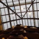 Pogled iz pritličja navzgor proti stekleni strehi. Okoli ograj je še adventna okrasitev.